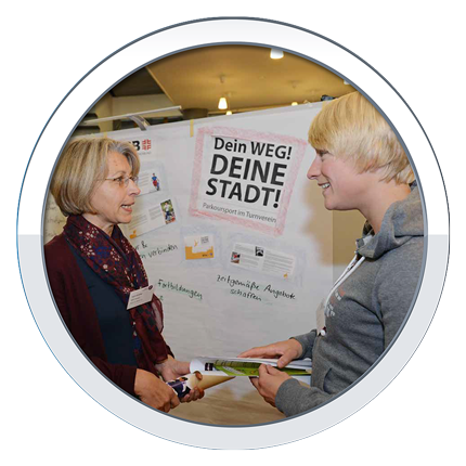 Zwei Frauen diskutieren vor einer Collage