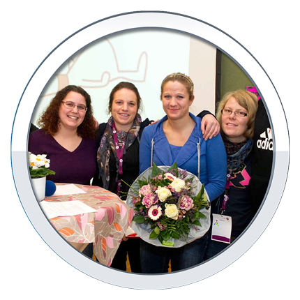 Gruppe von vier Frauen. Die 2. v.r. hält einen Blumenstrauß in den Händen. 