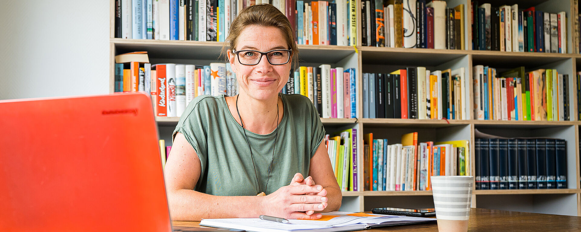 Kopfbild: Frauenportrait am Schreibtisch